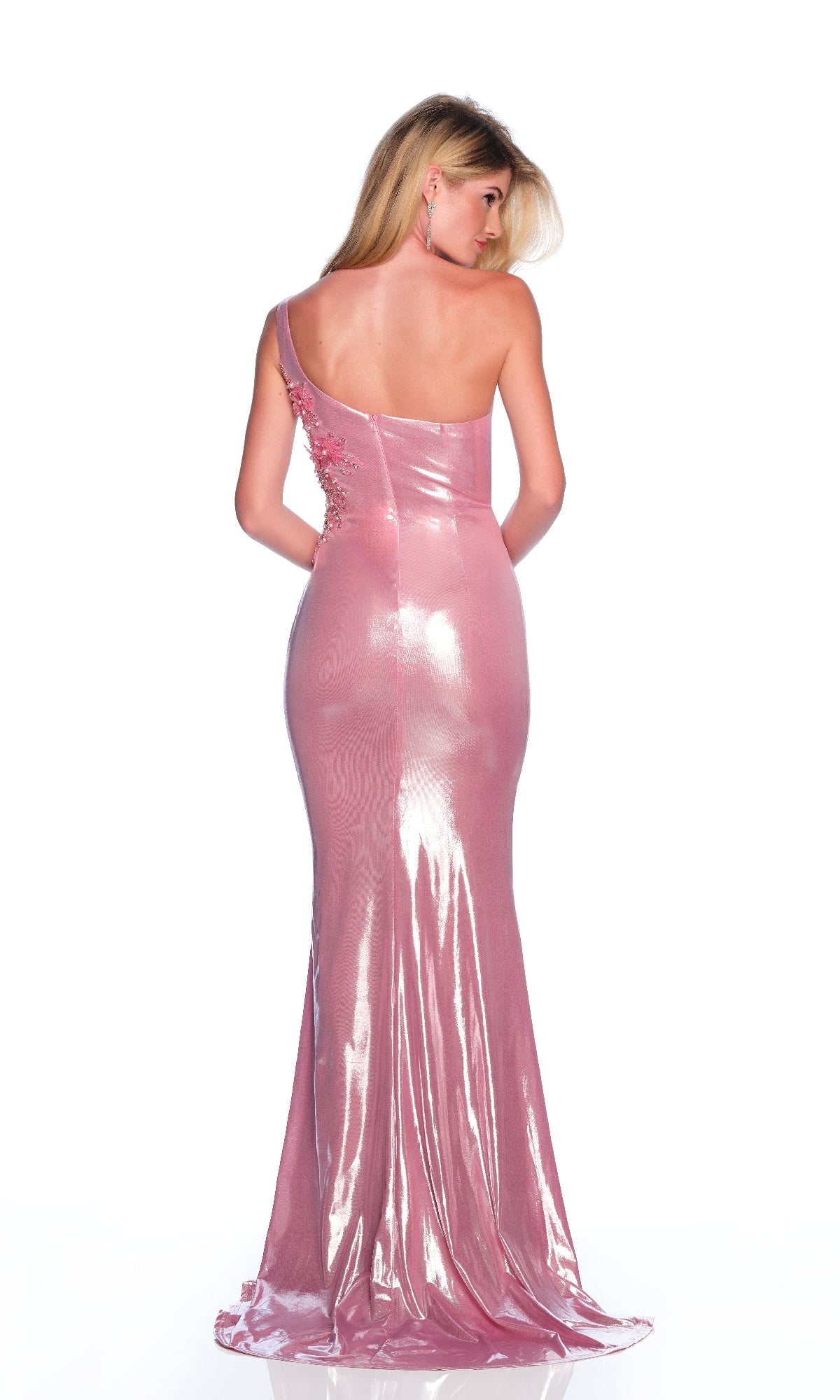 A woman stands facing away with hands behind her back, wearing the Dave & Johnny 12277 long pink prom dress, featuring beading and a one-shoulder design, set against a white background.